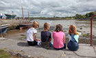 Young spectators waiting for the tide to rise for the traditional boat races at the Cruinniu na Mbad Festival at Kinvara Pier. 