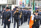 Garda Claire Burke carries the Irish flag at Eyre Square, at the re-enactment of the arrival of the first Gardaí to Galway on 25th September 1922, during the commemoration by Gardaí in Galway of the 100-year anniversary of the foundation of An Garda Síochána last Sunday.