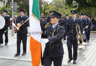 Garda Claire Burke carries the Irish flag at Eyre Square, at the re-enactment of the arrival of the first Garda√≠ to Galway on 25th September 1922, during the commemoration by Garda√≠ in Galway of the 100-year anniversary of the foundation of An Garda S√≠och√°na last Sunday.
