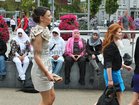 A contrast in style as a group of Saudi Arabian visitors look on as race goers make their way from Eyre Square to Ballybrit for Ladies Day at the Galway Races yesterday.