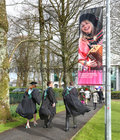 NUI Galway graduates make their way to the Bailey Allen Hall to receive their degrees as a banner with an image of Sharon Shannon smiles down at them. Sharon was conferred with an Honorary doctor of Music at the college in 2018.