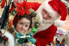 Santa Claus shows some Christmas gifts to Tulisa Kavanagh (6) from Bohermore at the Ballybane Christmas Fair in the Ballybane Community Centre last Saturday.