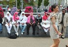 A contrast in style as a group of Saudi Arabian visitors look on as race goers make their way from Eyre Square to Ballybrit for Ladies Day at the Galway Races yesterday.