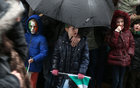 Children take shelter during the heavy rain at the St Patrick's Day Parade in the city. 