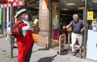 Brendan Holland of Hollands Newsagents on Williamsgate Street looks on as Galway Town Crier Liam Silke was out on the city centre streets on Monday welcoming back shoppers and thanking staff business owners, who have been able to reopen, after the easing of Covid-19 restrictions.