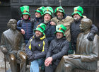 A group of visitors posing for a photograph at the Wilde statues on St Patric's Day.